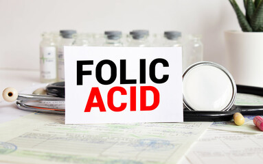 FOLIC ACID text written on card on wooden table with medical background
