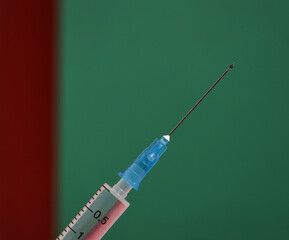 Syringe on green background