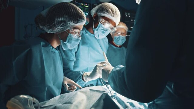 Experts in saving lives. Team of professional surgeons working at the hospital performing surgical procedure in operating theatre over a patient under anesthesia. Profession job career and experience
