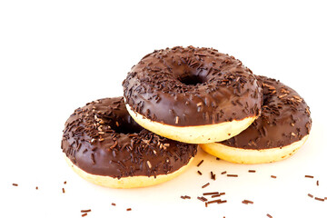 Delicious fresh chocolate donuts with sprinkles on an isolated white background.