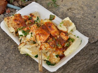 Spice tofu meal with a fresh herbs. Asian street food. Closeup shot.