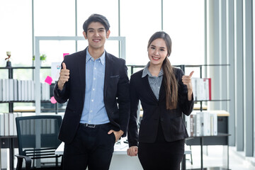 Portrait of a two businessman and businesswoman  partners discussing positive adult business showing thumbs up and ideas at meeting in office background