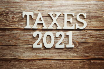 Taxes 2021 alphabet letter on wooden background