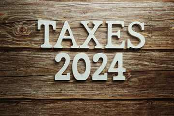 Fototapeta premium Taxes 2024 alphabet letter on wooden background
