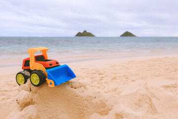 Fototapeta na wymiar Small Bulldozer toy on the beach, Lanikai, Oahu island, Hawaii