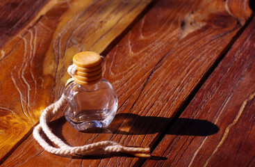 Fototapeta na wymiar An apple shaped perfume bottle with its shadow on wooden background.