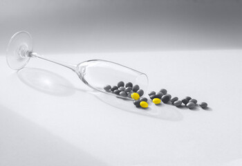 Trendy 2021 Ultimate Gray and Illuminating colors. Stylish composition with a transparent glass goblet and small candies.