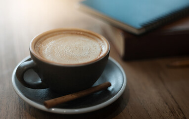 Close-up of coffee drink with book and blue diary on wooden table