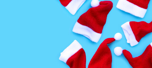 Fototapeta na wymiar Merry Christmas and Happy Holidays. Santa hats on blue background.