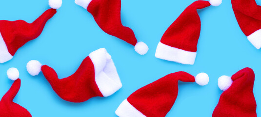 Merry Christmas and Happy Holidays. Santa hats on blue background.