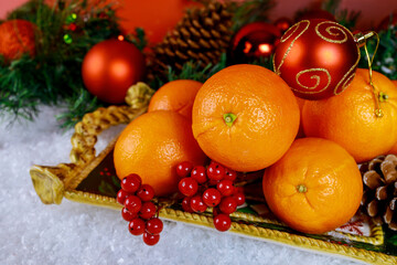 Seasonal oranges in christmas tray with ornament.