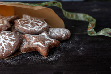 Homemade round and star shaped christmas gingerbreads on a dark wooden table