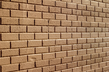 Full frame abstract texture background of a vintage traditional clay brick wall with mild grunge look, painted brown