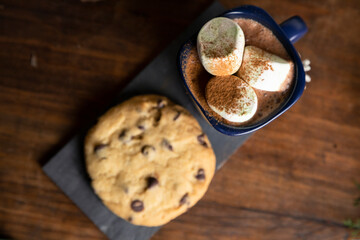 Top view elegant mugs with hot chocolate and marshmallows with cinnamon sprinkled on top - hot chocolate served on christmas table