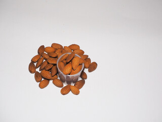 Almonds in a plastic cup on a white background