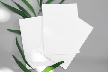 White paper mock-ups with leaves isolated on gray background, Blank portrait paper A4. brochure newspaper magazine, can use poster banners products business texture for your.