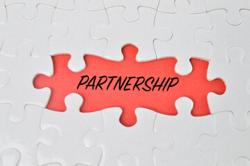 Fototapeta premium Top view of jigsaw puzzle with word PARTNERSHIP. Business and education concept.