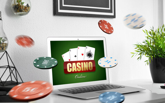 Text CASINO ONLINE on screen of laptop on table in room
