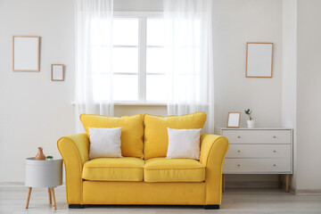 Stylish sofa near window in room