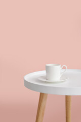 Fototapeta na wymiar Cup on stylish table near color wall in room