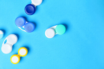 Containers with contact lenses on color background