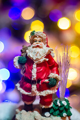 Papa Noel on the background of colorful lights. Christmas decor.