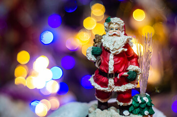 Papa Noel on the background of colorful lights. Christmas decor.