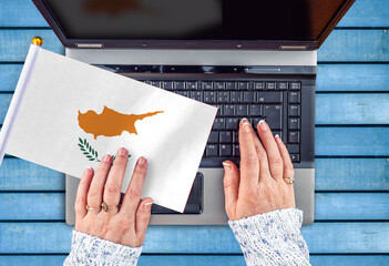 woman hands and flag of Cyprus on computer, laptop keyboard 