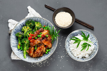 Rice topped with fried chicken served with steamed broccoli