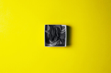 Gray confetti on yellow background - trendy colors of 2021.