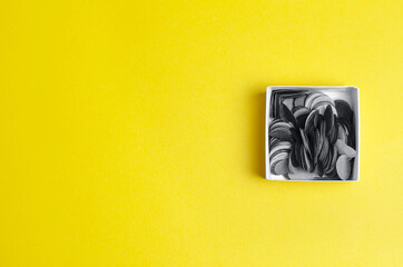 Gray confetti on yellow background - trendy colors of 2021.