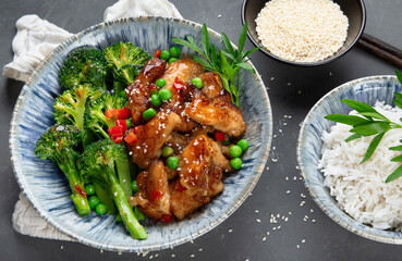 Rice topped with fried chicken served with steamed broccoli