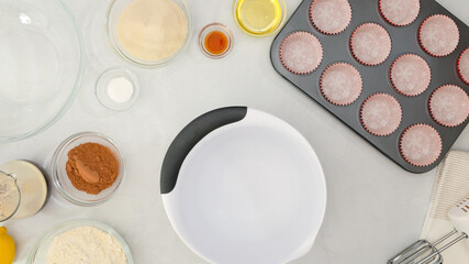 Muffin pan with paper cupcake liners, and ingredients for chocolate muffins or chocolate cupcakes recipe close up on kitchen table.