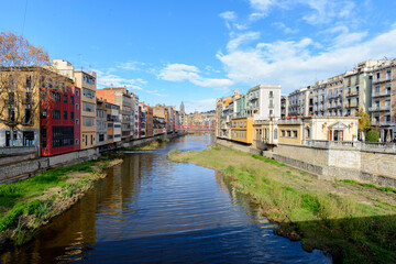 Fototapeta premium Vista escénica de la ciudad de Girona , casa típicas colores anaranjados sobre el rio Onyar un dia soleado de Diciembre. Girona, Cataluña, España