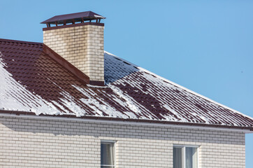 Snow on the roof of the house.