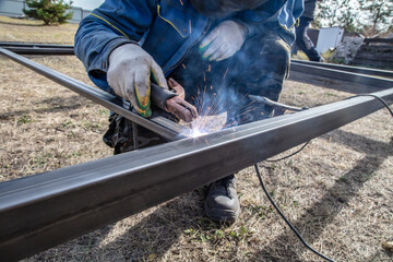 A worker welds metal at a construction site. Technology