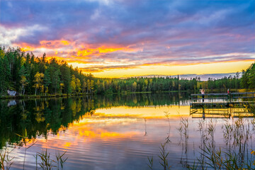 Woman enjoying beautiful sunset at the lake in autumn