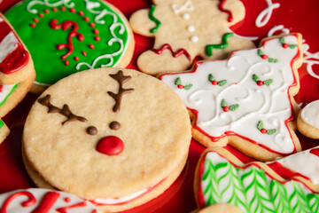 Red plate full of colorfully decorated Christmas cookies - Christmas eve recipes - Christmas holiday culinary traditions