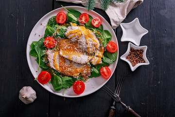 Cold boiled pork meat with sweet and sour sauce, spinach leaves, cherry tomatoes and grated cheese. Pan-Asian cuisine. Top view