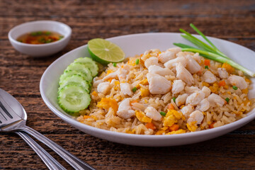 Fried rice with crab on white plate and chili fish sauce in bowl