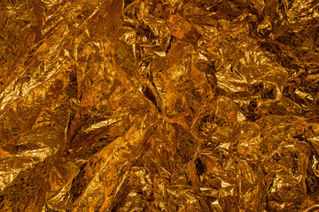 The wrinkled texture of golden side weather blanket (thermal blanket, heat sheet) that is being used as a camping or first aid equipment