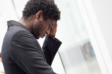 Upset stressed African black businessman having headache, portrait of failed unhappy black business man, concept of work problem, office stress syndrome, economic recession, layoff, unemployment