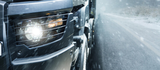 The truck is driving on a winter road. Close-up of headlights