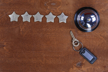 five stars hotel, service bell and hotel key on a wooden table
