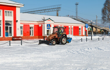 Samara, Chapaevsk, Russia-February.20.2018: Snow plow truck cleaning the forecourt of the street of...