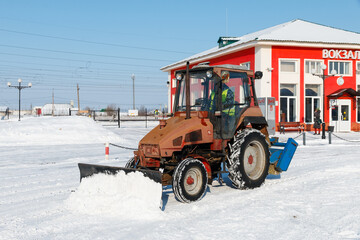 Samara, Chapaevsk, Russia-February.20.2018: Snow plow truck cleaning the forecourt of the street of...