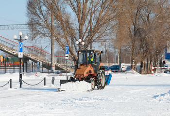 Samara, Chapaevsk, Russia-February.20.2018: Snow plow truck cleaning the forecourt of the street of Winter, the concept of snow © yakowiric1959