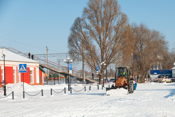 Samara, Chapaevsk, Russia-February.20.2018: Snow plow truck cleaning forecourt area streets Winter snow removal concept city landscape background horizontal © yakowiric1959