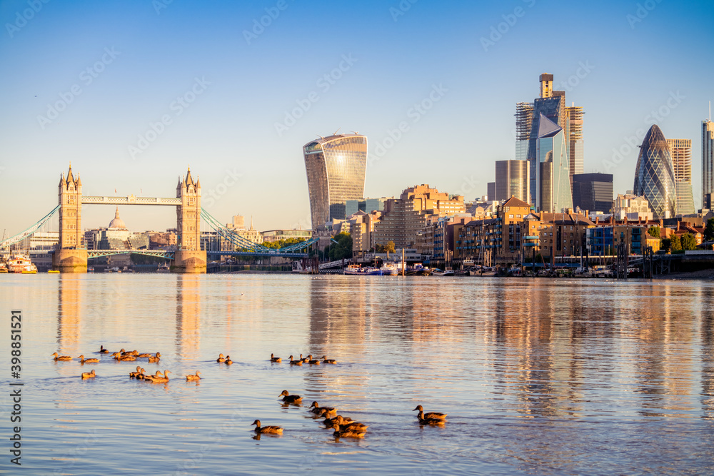 Poster tower bridge and financial district of london in morning light. united kingdom