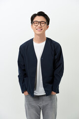 Cheerful young Asian handsome man putting his hands in his pockets over white background.